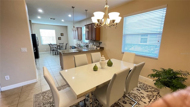 dining room featuring visible vents, a notable chandelier, baseboards, and light tile patterned floors