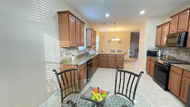 kitchen with light stone countertops, black appliances, brown cabinets, and decorative light fixtures