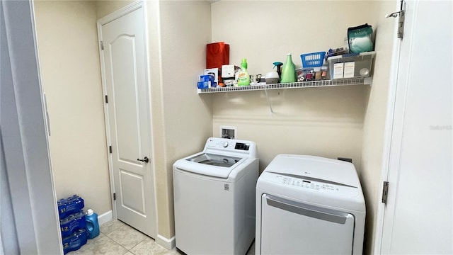 laundry area with light tile patterned floors, laundry area, baseboards, and washer and dryer