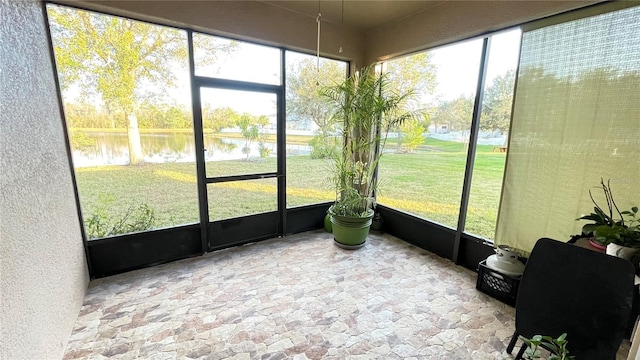 sunroom featuring a water view