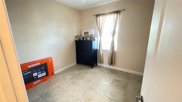 interior space with baseboards and light tile patterned floors