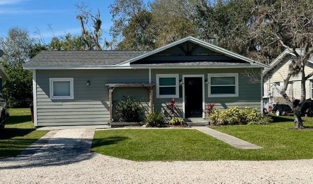 view of front facade with gravel driveway and a front yard