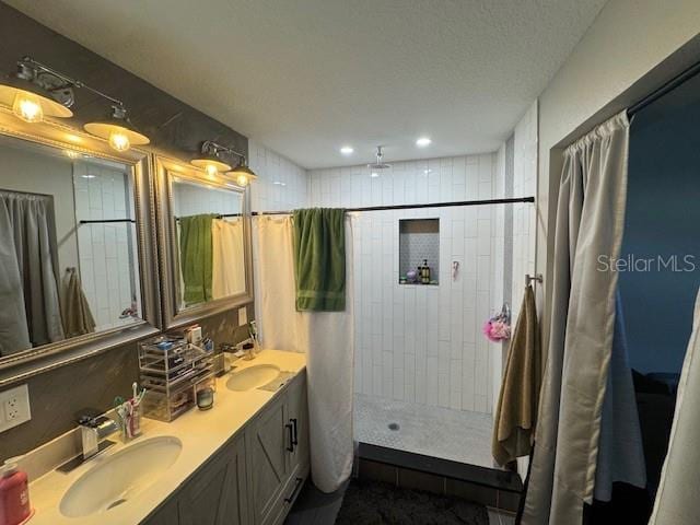 bathroom with double vanity, walk in shower, and a sink