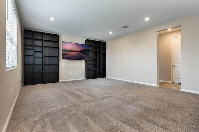 empty room featuring light carpet, baseboards, and recessed lighting