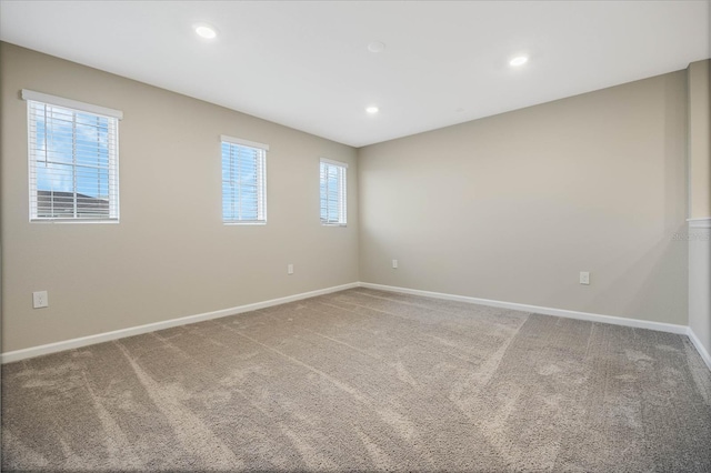 empty room featuring recessed lighting, carpet, and baseboards