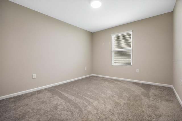 carpeted spare room with baseboards