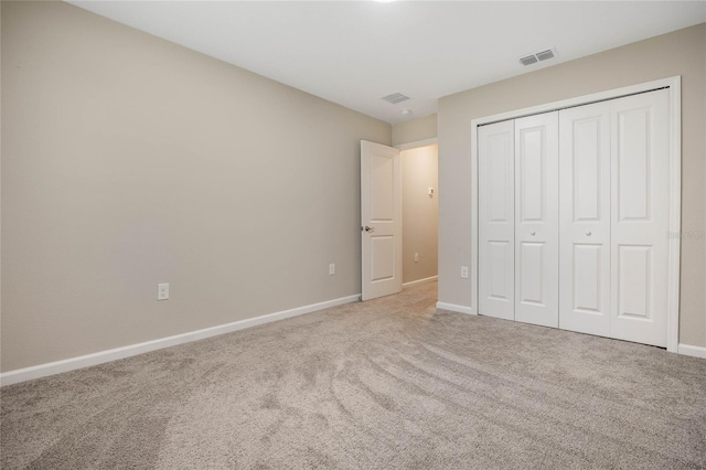 unfurnished bedroom with light carpet, a closet, visible vents, and baseboards