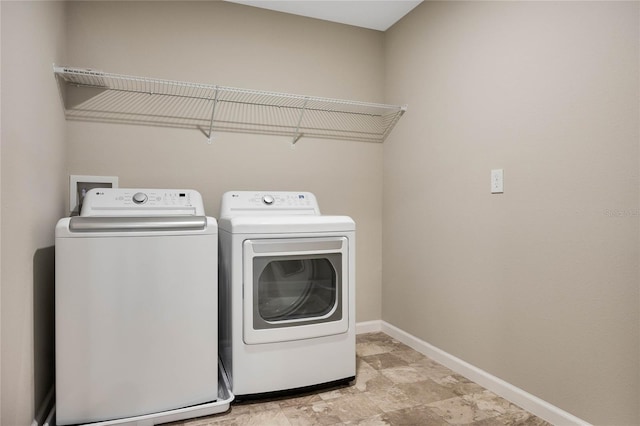 laundry room with laundry area, washer and clothes dryer, and baseboards