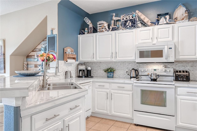 kitchen featuring light tile patterned floors, light countertops, white appliances, and backsplash