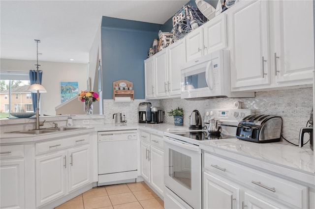 kitchen with light tile patterned floors, white appliances, a sink, white cabinets, and decorative backsplash