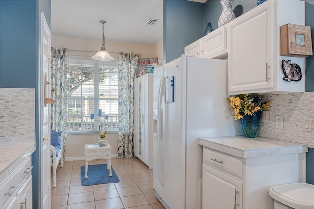 kitchen featuring light tile patterned floors, white refrigerator with ice dispenser, decorative backsplash, light countertops, and white cabinetry