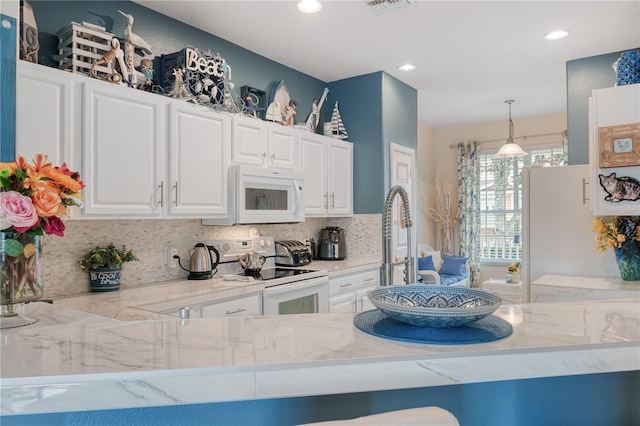 kitchen with white appliances, white cabinets, backsplash, light stone countertops, and pendant lighting