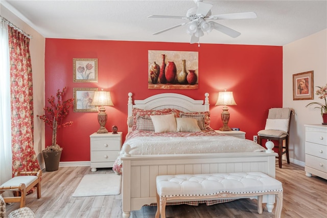 bedroom with ceiling fan, baseboards, and wood finished floors