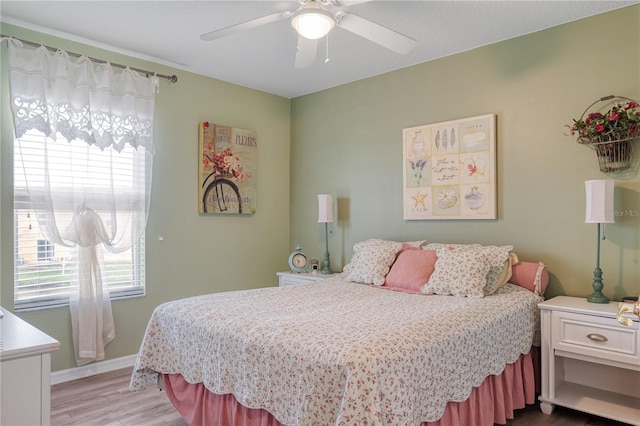 bedroom with light wood-style floors, baseboards, and a ceiling fan