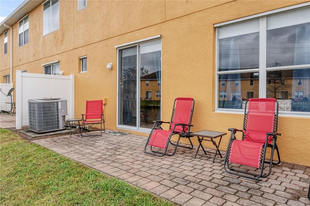 view of patio with cooling unit and fence