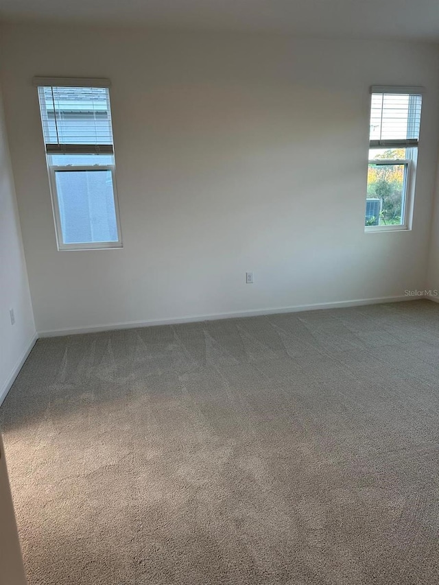 empty room featuring carpet flooring and baseboards