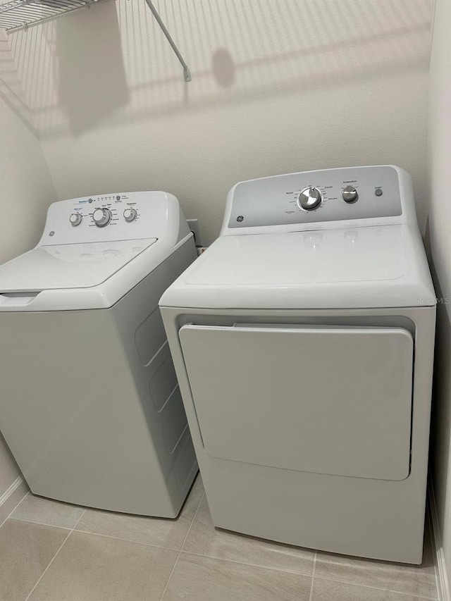 laundry room with laundry area, light tile patterned floors, and separate washer and dryer