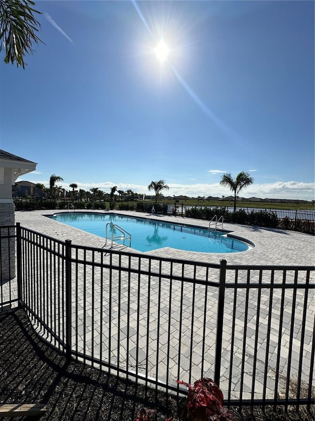 community pool with fence and a patio