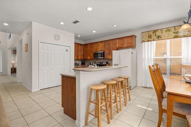 113 Tiger Lily Ct, Davenport, FL 33837 - kitchen with appliances with stainless steel finishes, light tile patterned floors, backsplash, light countertops, and recessed lighting