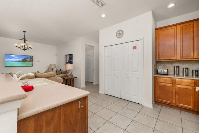 113 Tiger Lily Ct, Davenport, FL 33837 - kitchen with a sink, brown cabinetry, light countertops, light tile patterned flooring, and open floor plan
