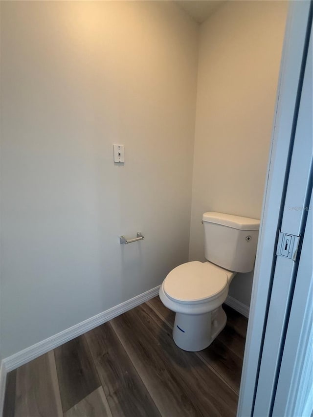 bathroom featuring toilet, baseboards, and wood finished floors