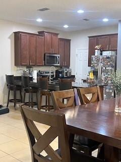 kitchen with recessed lighting, stainless steel microwave, visible vents, and light tile patterned flooring