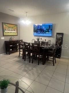 dining space featuring baseboards and light tile patterned flooring