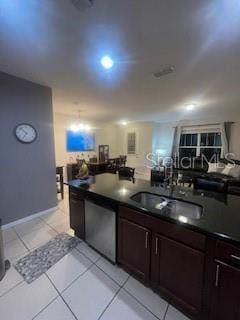 kitchen with light tile patterned flooring, a sink, dark brown cabinets, stainless steel dishwasher, and dark countertops