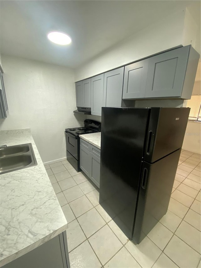 kitchen featuring gray cabinets, light countertops, black appliances, a sink, and light tile patterned flooring