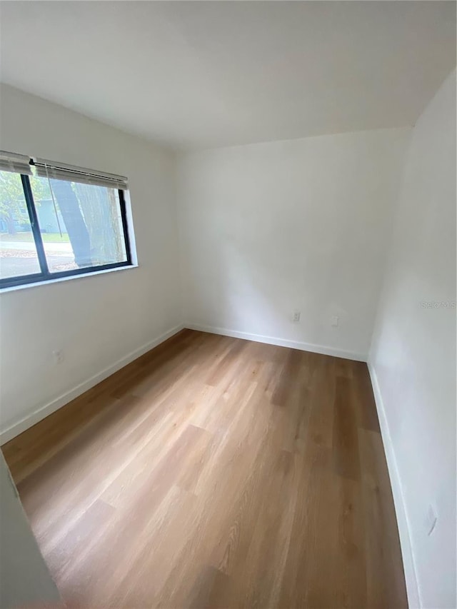 spare room featuring light wood-style flooring and baseboards