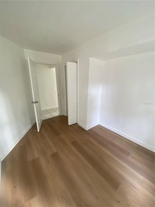 unfurnished bedroom featuring dark wood-style floors and baseboards