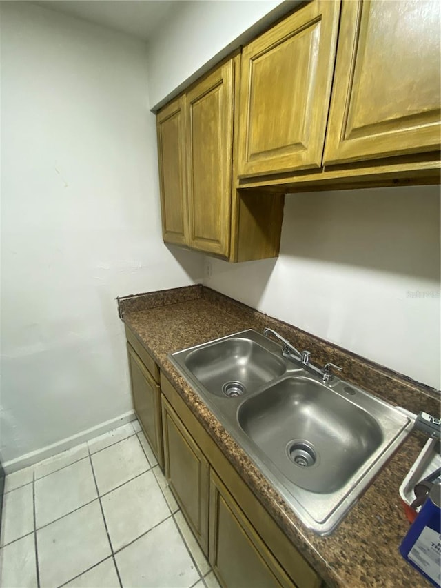 kitchen with dark countertops, a sink, and brown cabinets