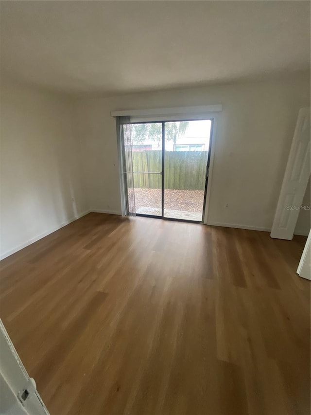 empty room featuring baseboards and wood finished floors