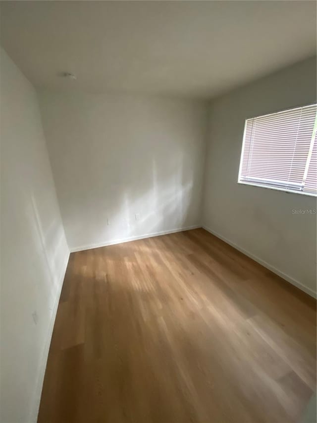 spare room with light wood-style floors and baseboards