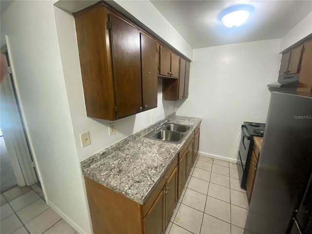 kitchen featuring light tile patterned floors, baseboards, black range with electric stovetop, under cabinet range hood, and a sink