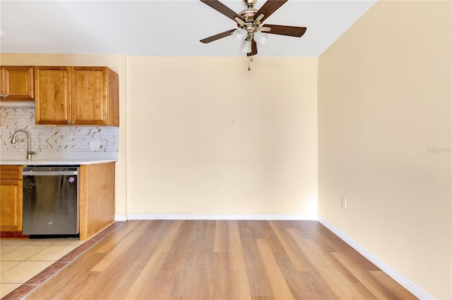 1695 Lee Rd Unit E103, Winter Park, FL 32789 - kitchen featuring stainless steel dishwasher, light countertops, ceiling fan, backsplash, and brown cabinets
