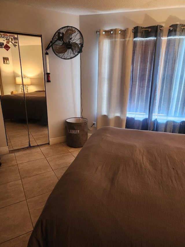 bedroom with light tile patterned floors and a textured ceiling