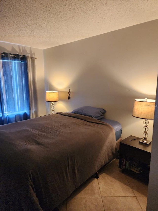 bedroom featuring light tile patterned floors and a textured ceiling