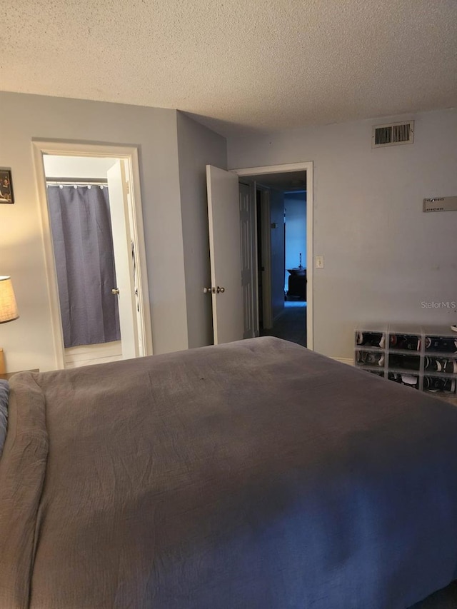 bedroom featuring a textured ceiling and visible vents