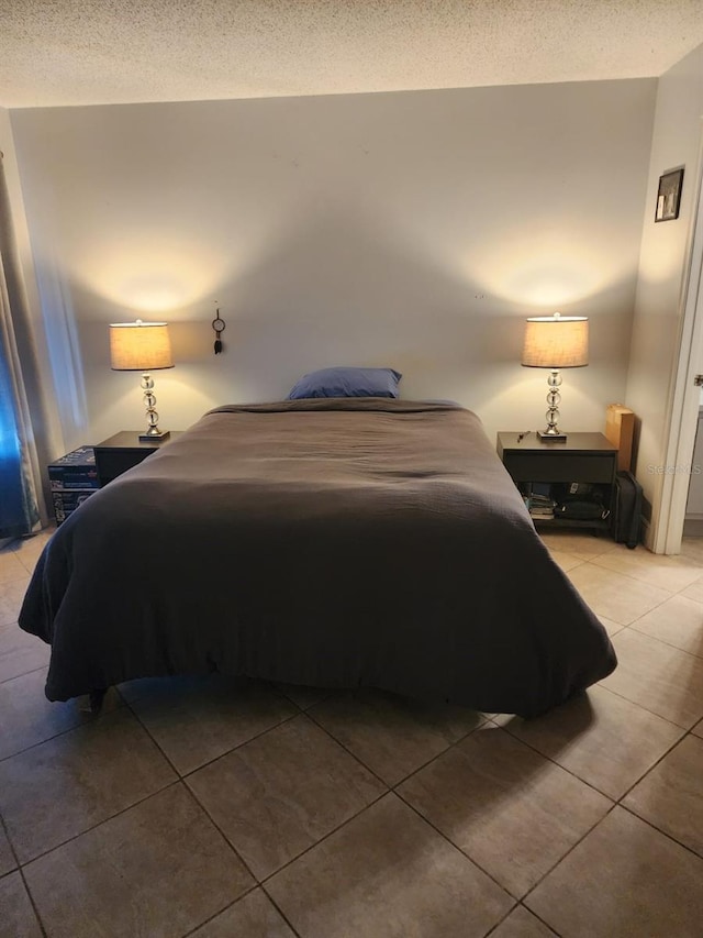 bedroom featuring a textured ceiling and tile patterned floors