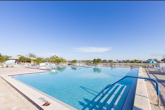 pool with a patio and fence