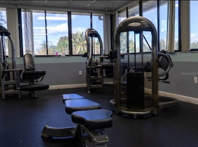 exercise room featuring plenty of natural light and baseboards