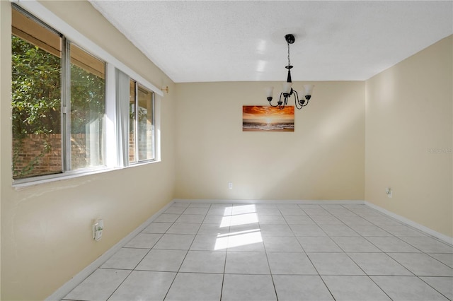 406 Oak Haven Dr Unit 406, Altamonte Springs, FL 32701 - empty room featuring light tile patterned flooring, a notable chandelier, a textured ceiling, and baseboards