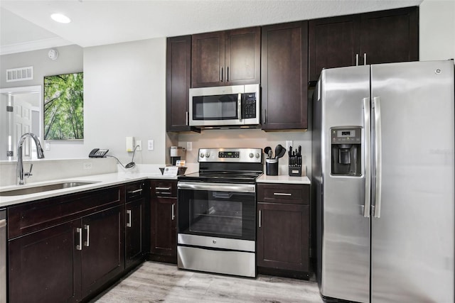 kitchen with stainless steel appliances, light countertops, a sink, and visible vents