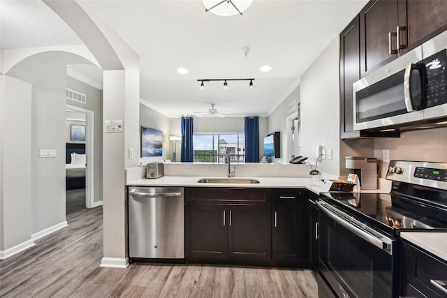 kitchen with dark brown cabinetry, a sink, visible vents, light countertops, and appliances with stainless steel finishes