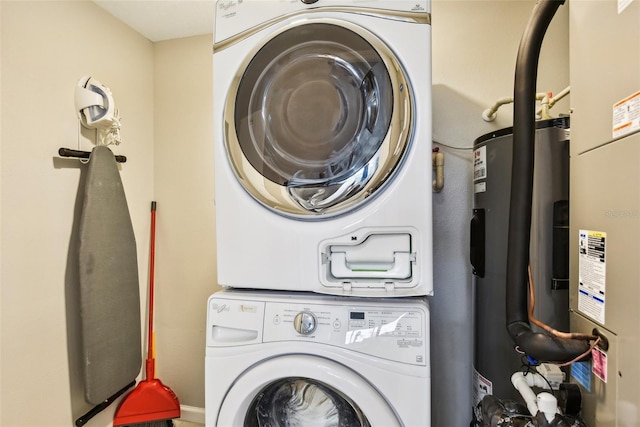 clothes washing area featuring laundry area, electric water heater, and stacked washer / drying machine