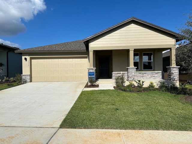 view of front of house featuring a garage, driveway, stone siding, covered porch, and a front lawn