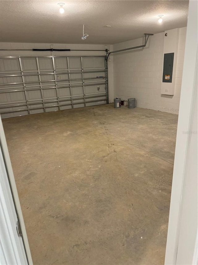 garage featuring concrete block wall and electric panel