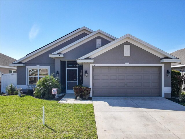 view of front of home featuring a garage, concrete driveway, a front lawn, and stucco siding