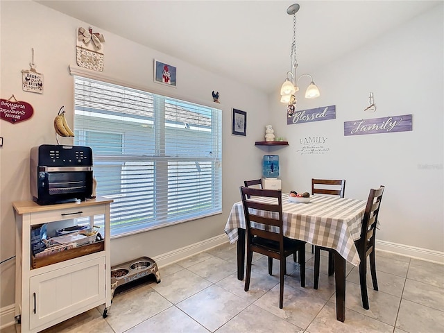 649 Meadow Pointe Dr, Haines City, FL 33844 - dining area with light tile patterned floors, baseboards, and an inviting chandelier